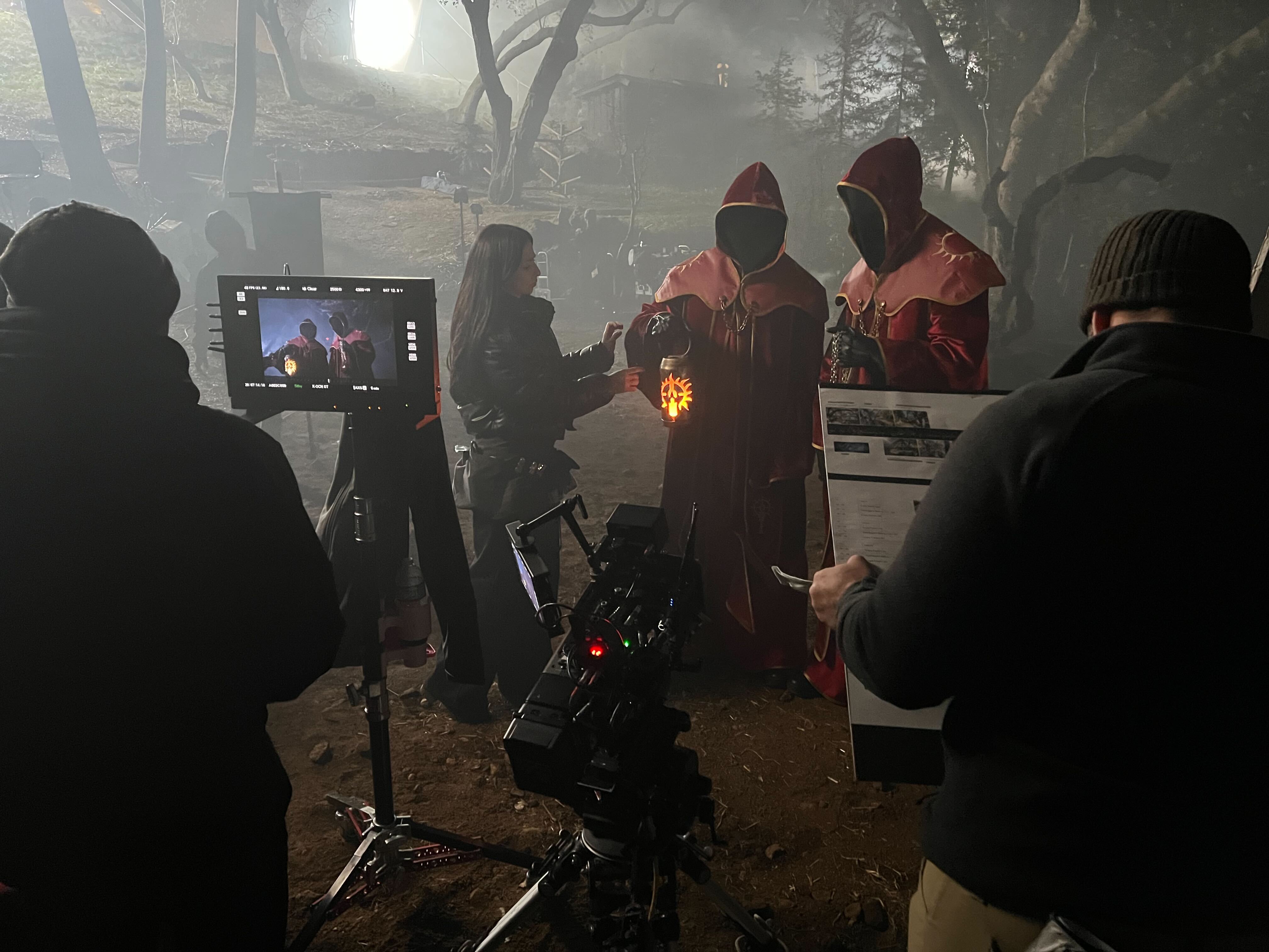 Crew preparing performers beside the production camera and monitor